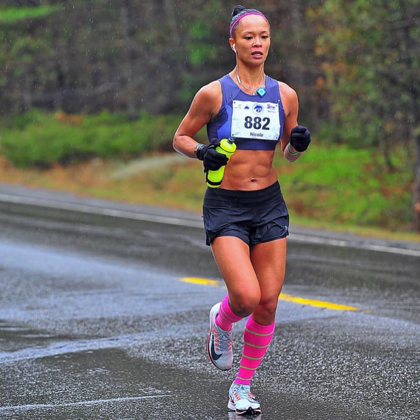 Woman running a marathon wearing PRO Compression knee-high socks