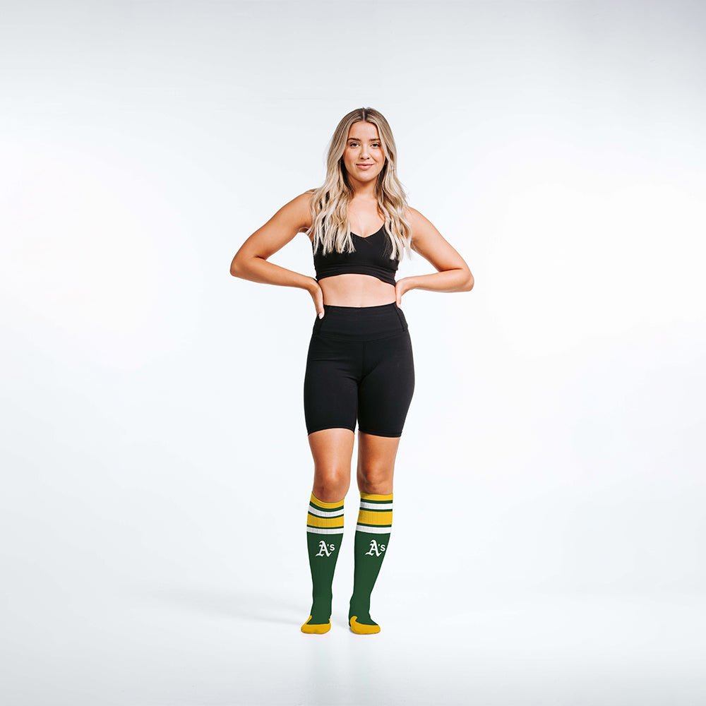 Woman wearing PRO Compression Major League Baseball Knee High Compression Sock Genuine MLB Merchandise Sock Oakland Athletics