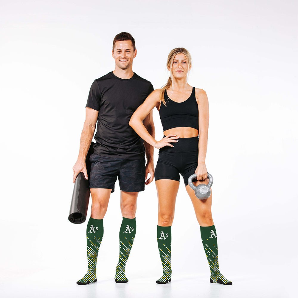 Man and woman wearing PRO Compression Major League Baseball Knee High Compression Sock Genuine MLB Merchandise Sock Oakland Athletics