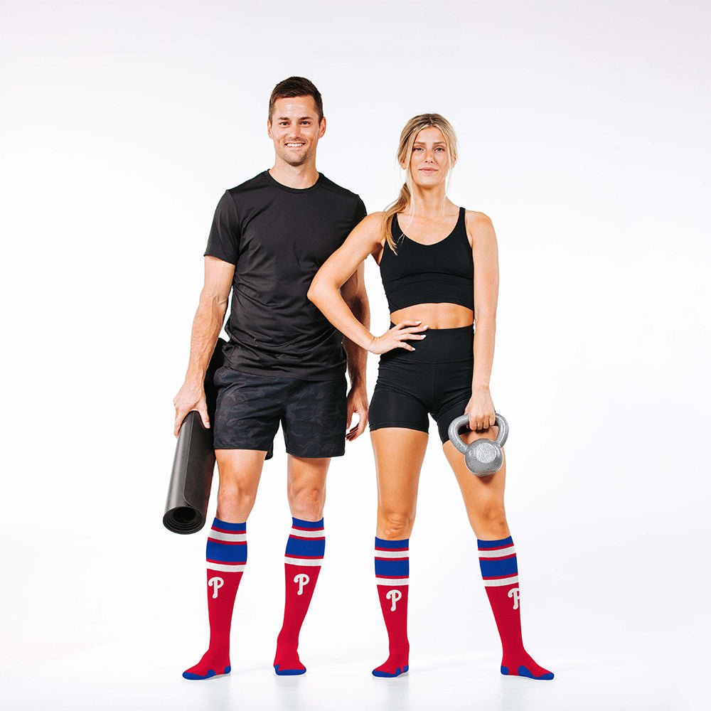 Man and woman wearing PRO Compression Major League Baseball Knee High Compression Sock Genuine MLB Merchandise Sock Philadelphia Phillies
