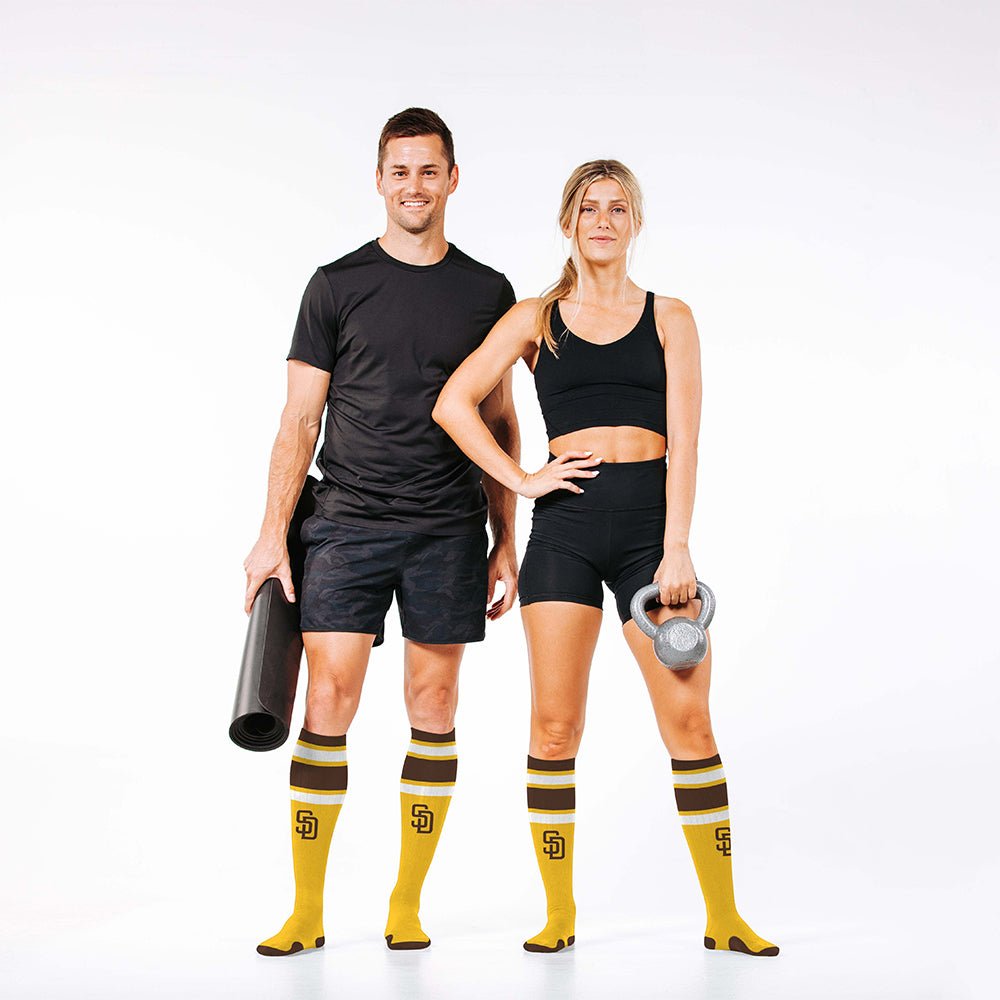 Man and woman wearing PRO Compression Major League Baseball Knee High Compression Sock Genuine MLB Merchandise Sock San Diego Padres
