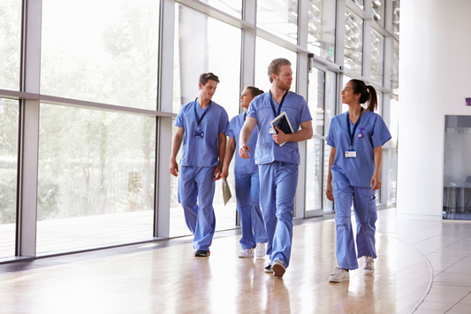 Group of nurses in scrubs walking indoors