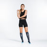 Knee high compression socks in navy blue with light blue dots on model looking up