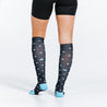 Knee high compression socks in navy blue with light blue dots on model close up rear view