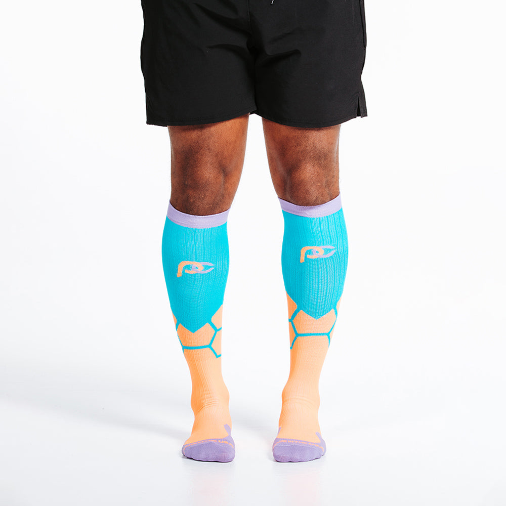 Orange BOOM design in PRO Compression knee high compression socks. Bright orange and teal design with lavender cuff, toe and heel boxes - on model, close up