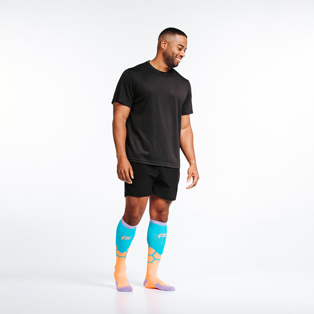 Orange BOOM design in PRO Compression knee high compression socks. Bright orange and teal design with lavender cuff, toe and heel boxes - on male model