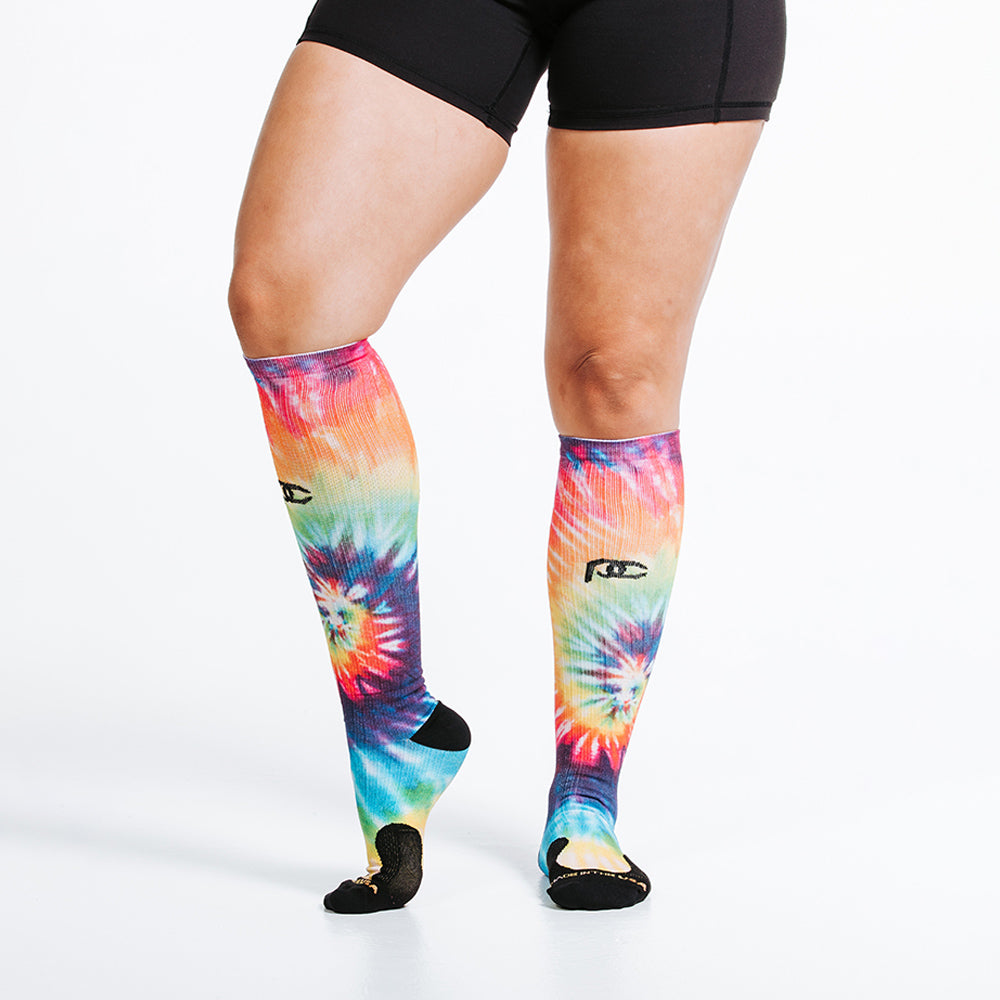 Knee high rainbow tie dye compression socks - close up on feet angled side