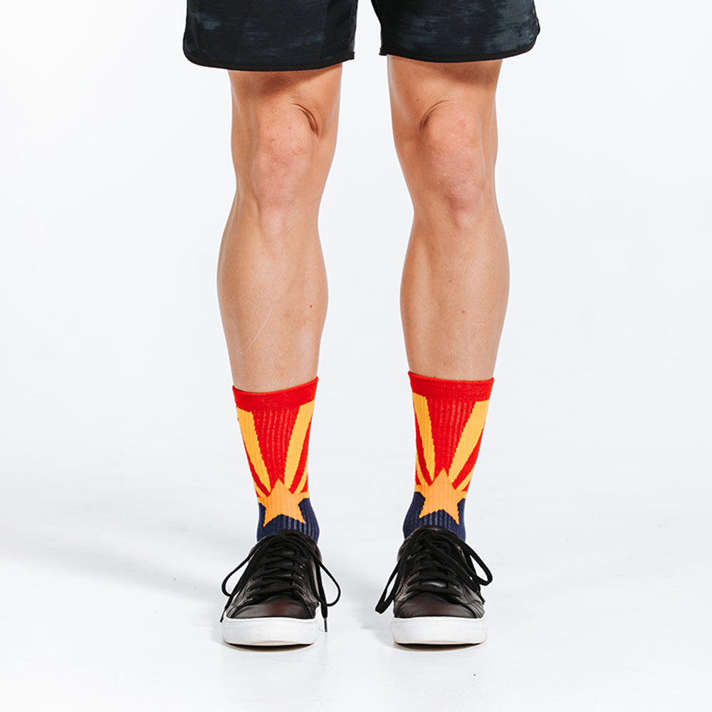 Crew length compression socks with navy blue, red, and golden star design - close up on model