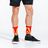 Crew length compression socks with navy blue, red, and golden star design - close up on model feet