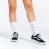 White compression socks with faded red and purple polka dots - close up on model wearing Vans shoes