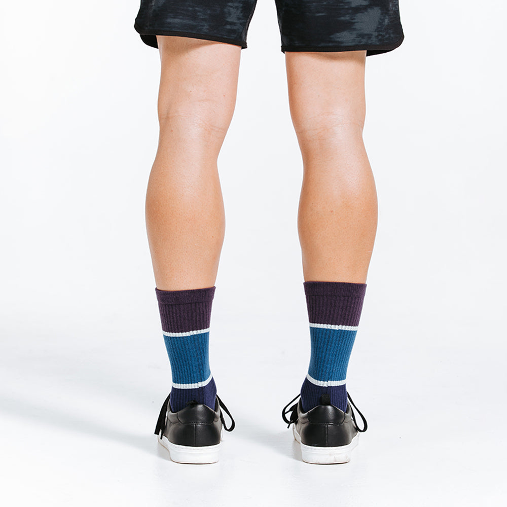 Blue crew length compression socks on model - back view