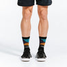 Crew length black compression socks with colorful accents and gold toes - close up of feet