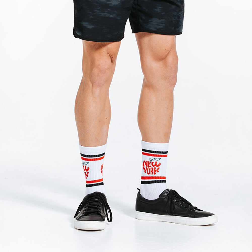 White crew length compression socks with black and red New York City design on model - close up