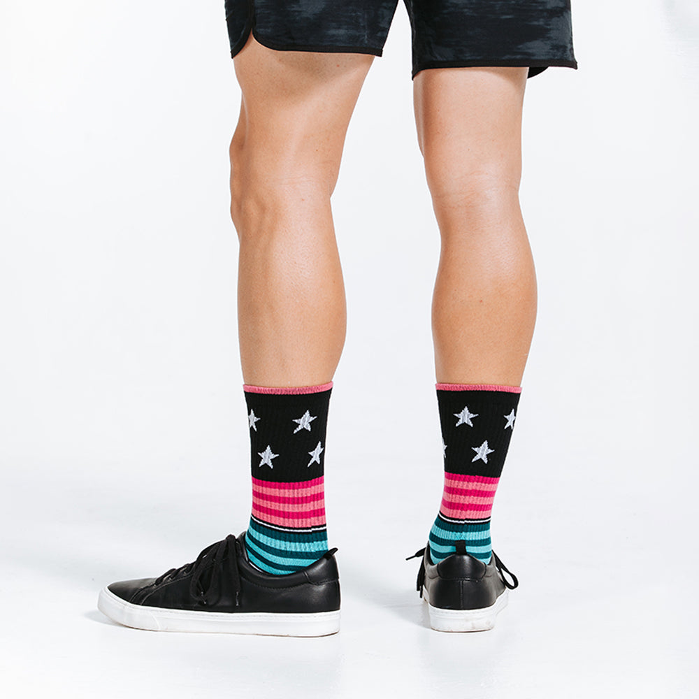 Colorful crew length compression socks with stars - posterier view close up on model