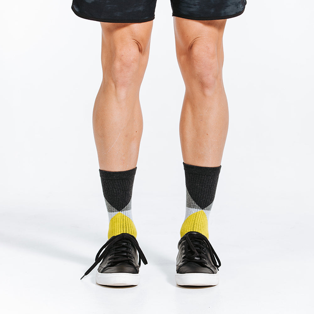 Black, grey, and yellow crew length compression socks - close up on feet