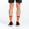 Orange crew length compression socks with blue bands - close up on socks 