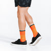 Orange crew length compression socks with blue bands - close up on model walking in socks