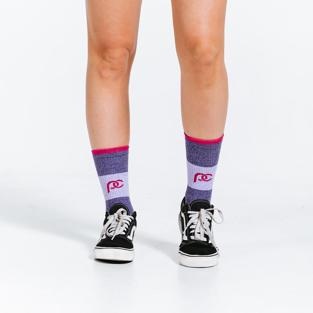 Compression socks in crew length - purple color block with pink bands - close up on feet 