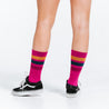 Pink, gold, and navy blue crew length compression socks - close up on feet rear view