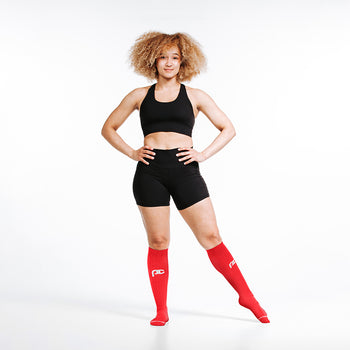 Knee-high Recovery Compression Sock 25-35 mmHg | Female wearing red knee high compression socks
