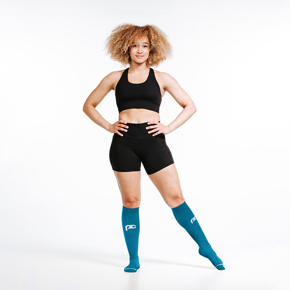 Knee-high Recovery Compression Sock 25-35 mmHg | Female wearing turquoise knee high compression socks