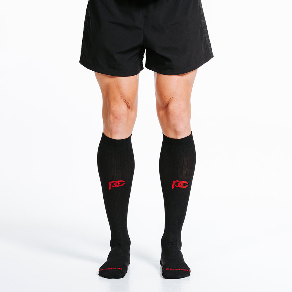PRO Compression Marathon socks for running and recovery close up of man wearing black knee-high sock