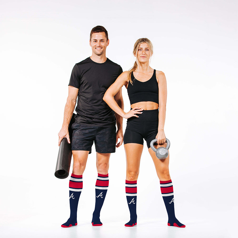 Man and woman wearing PRO Compression Major League Baseball Knee High Compression Sock Genuine MLB Merchandise Sock Atlanta Braves